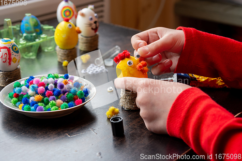 Image of A child makes a gift egg for the Easter holiday