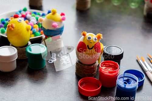 Image of Easter egg crafts, paints and decorative elements are on the table