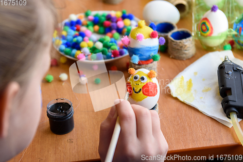 Image of Girl beautifully paints Easter eggs