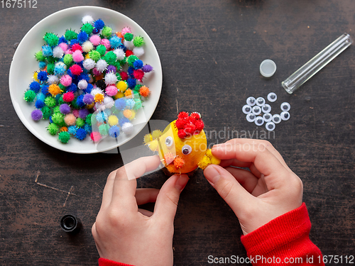 Image of Childrens hands make chicken from eggshell for easter holiday, top view