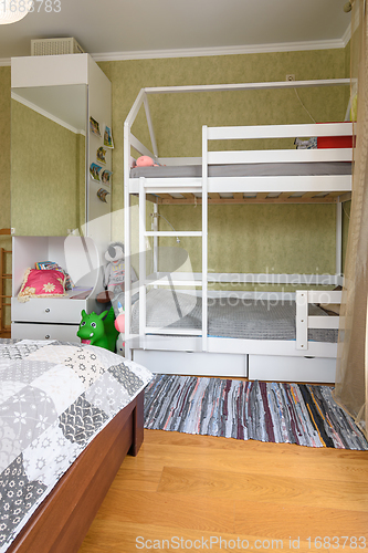 Image of Fragment of the interior of a bedroom with a large double bed and a children\'s bunk bed