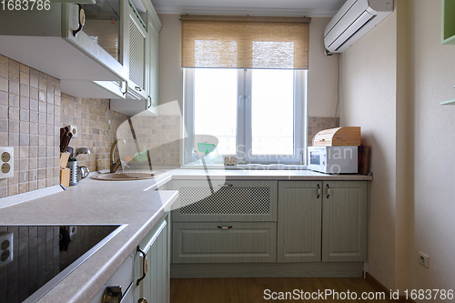 Image of Fragment of a corner kitchen set in the interior of the kitchen with a large window