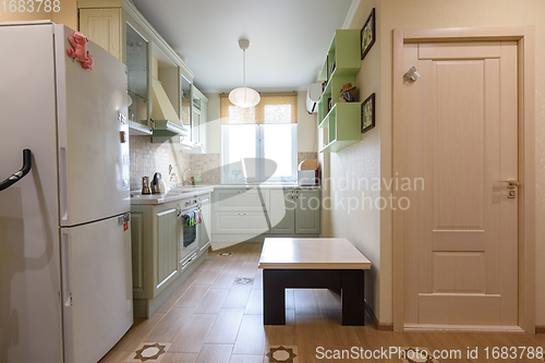 Image of The interior of the living room combined with the kitchen, in the foreground is the door to the room