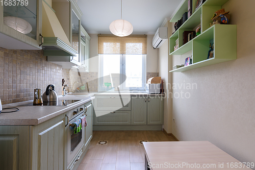 Image of The interior of a light ordinary kitchen with a spacious kitchen set