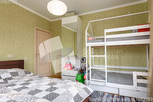 Image of Bedroom interior with a large double bed and a children\'s bunk bed