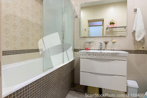 Image of Bathroom interior, the bathroom is separated from the washbasin by a glass partition