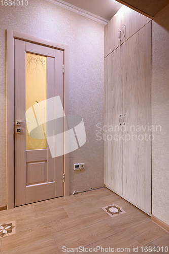 Image of View of the door to the toilet room and a large wardrobe in the interior of the hallway