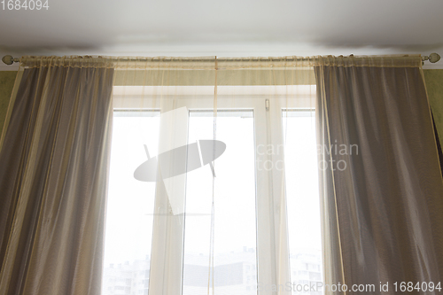 Image of Curtains and tulle curtains large plastic windows in the apartment, close-up