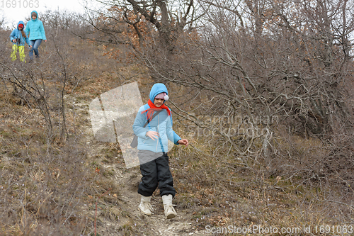 Image of A girl runs down the path from the mountain, in the background a girl with another girl gently descend from the mountain