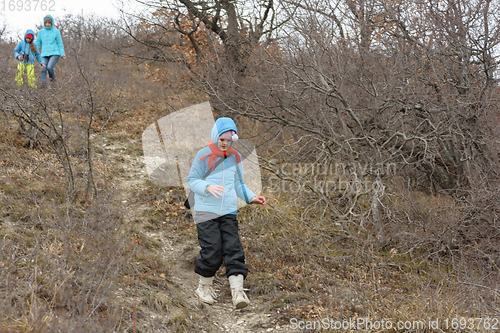 Image of A girl runs down the path from the mountain, in the background a girl with another girl gently descend from the mountain