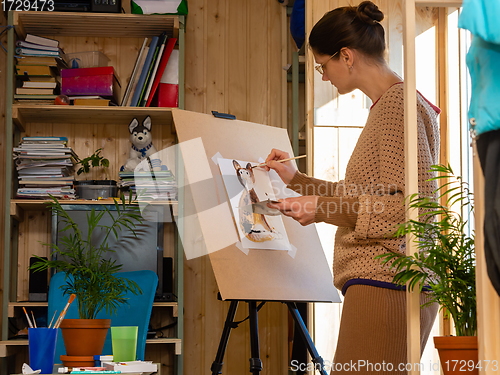 Image of Girl artist draws on an easel at home