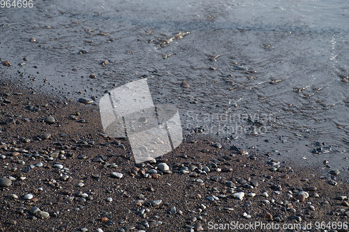 Image of ocean water on black sand