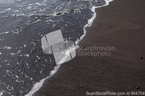 Image of ocean water on black sand