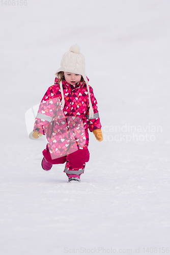 Image of little girl having fun at snowy winter day
