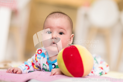 Image of newborn baby boy playing on the floor