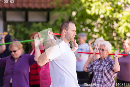 Image of trainer training motivated active healthy senior people