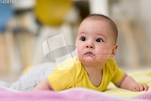 Image of newborn baby boy playing on the floor