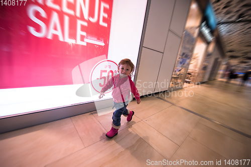 Image of little girl running through shopping mall