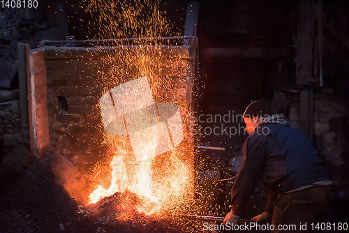 Image of young traditional Blacksmith working with open fire