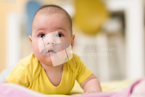 Image of newborn baby boy playing on the floor