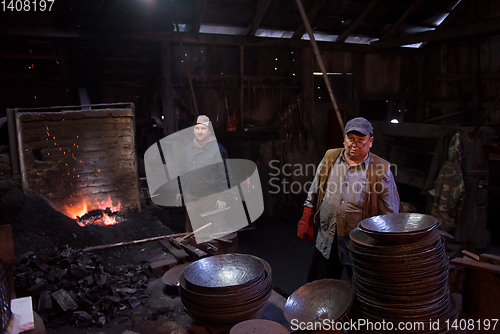Image of portrait of two generations traditional blacksmith