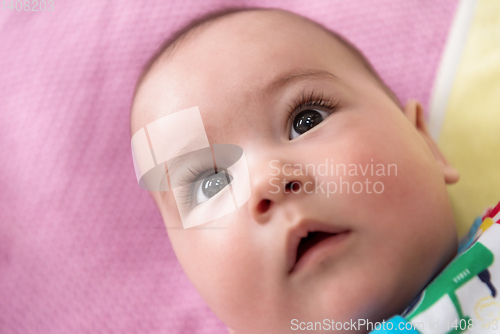 Image of top view of newborn baby boy lying on colorful blankets