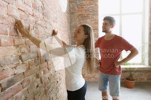 Image of Young couple doing apartment repair together themselves