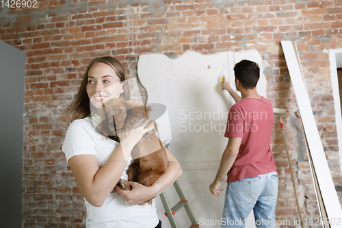 Image of Young couple doing apartment repair together themselves