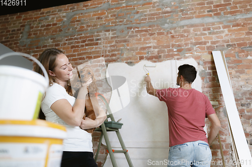 Image of Young couple doing apartment repair together themselves