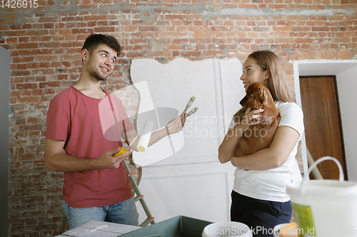 Image of Young couple doing apartment repair together themselves