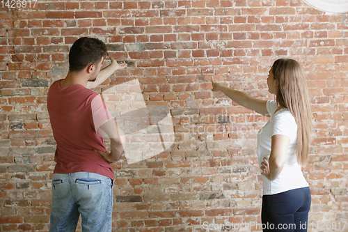 Image of Young couple doing apartment repair together themselves