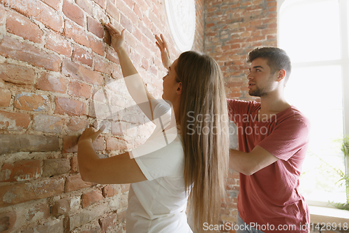 Image of Young couple doing apartment repair together themselves