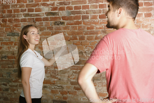 Image of Young couple doing apartment repair together themselves