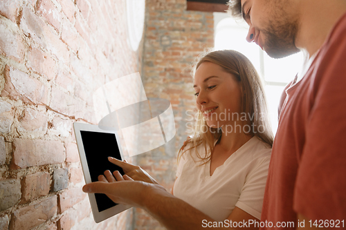 Image of Young couple doing apartment repair together themselves