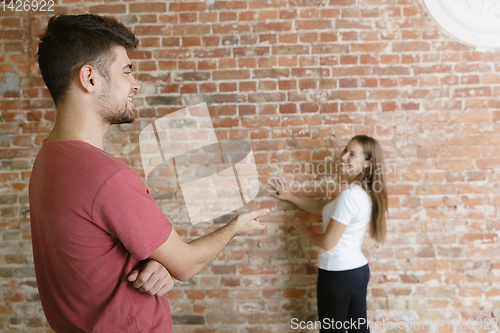 Image of Young couple doing apartment repair together themselves