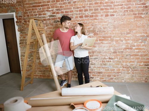 Image of Young couple doing apartment repair together themselves