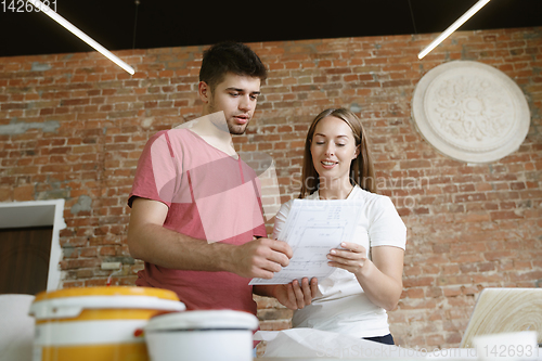 Image of Young couple doing apartment repair together themselves