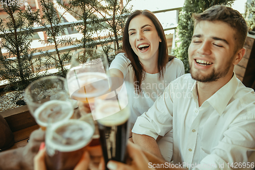 Image of Young group of friends drinking beer and celebrating together