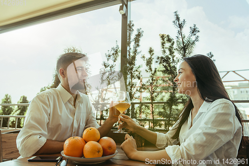 Image of Young friends or couple drinking beer and celebrating together