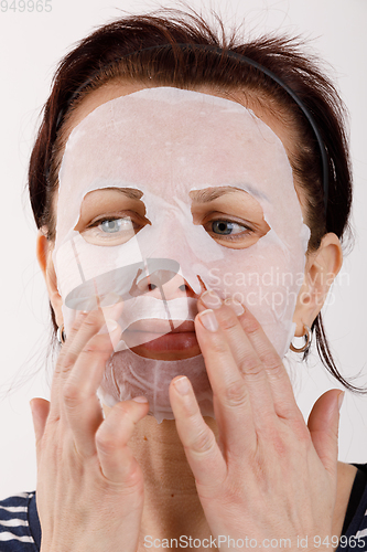 Image of housewife woman with a sheet mask on her face