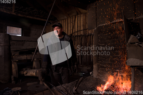 Image of young traditional Blacksmith working with open fire