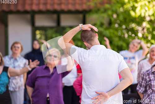 Image of trainer training motivated active healthy senior people