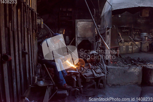 Image of the blacksmith polishing metal products