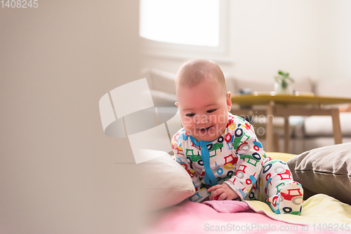 Image of newborn baby boy sitting on colorful blankets