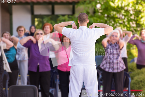 Image of trainer training motivated active healthy senior people