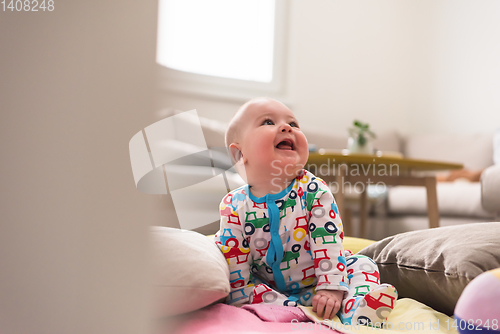 Image of newborn baby boy sitting on colorful blankets