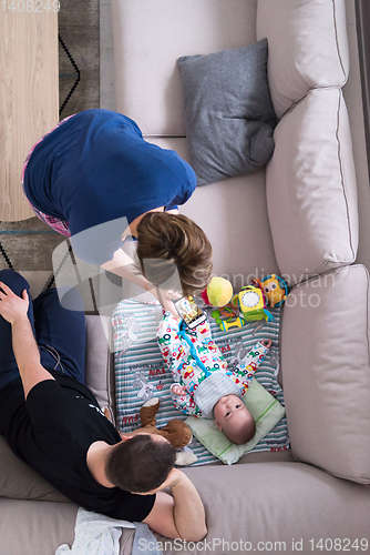 Image of top view of happy mother and father taking picture of baby