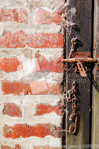 Image of Rough wood door and brick wall