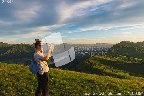 Image of Woman taking photo in mountain