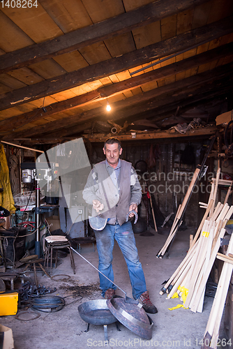 Image of A blacksmith worker showing handmade products ready for sale